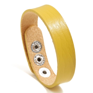 Details des ingwerfarbenen Lederarmbands mit Litschi-Struktur und silbernen Druckknöpfen