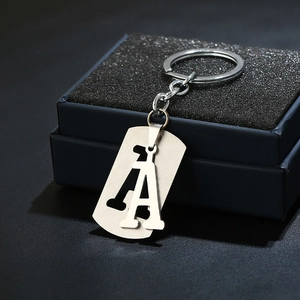 Detail view of a brushed stainless steel letter A keychain with a premium black gift box