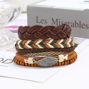 Detail view of multilayer braided leather bracelets with feather charm and wooden beads