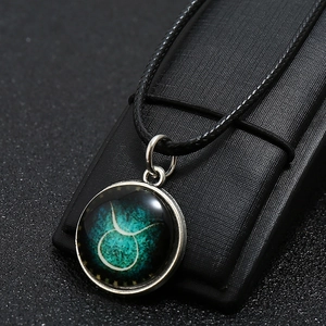 Detailed view of Taurus zodiac necklace with glowing nebula pendant and silver metal frame
