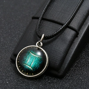 Detailed macro view of Gemini zodiac pendant necklace with glowing celestial pattern