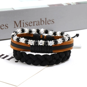 Détail d'un ensemble de bracelets en cuir tressé avec perles sur fond rétro élégant
