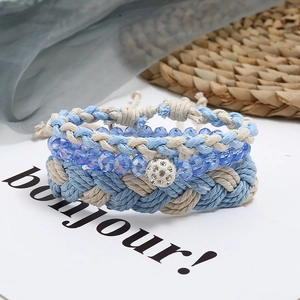 Primo piano di bracciali boho intrecciati e perle di cristallo sfaccettato azzurro