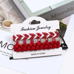 Ensemble de trois bracelets en corde de cire rouge et perles de cristal sur carte