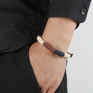 Handmade bohemian braided rope bracelet in cream, brown and navy blue on female wrist