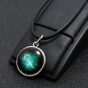 Macro shot of Sagittarius constellation necklace with silver border and black woven rope