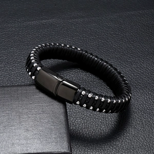 Detailed view of black braided leather men's bracelet with magnetic clasp and silver beads