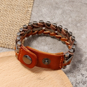 Retro multi-layer woven leather bracelet with metal clasp on a wooden display stand