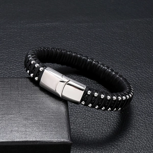 Detail showing woven black leather textures with embedded silver beads and polished metal clasp