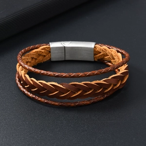 Detail of layered brown braided PU leather bracelet with brushed silver metal clasp