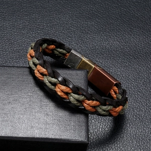 Close-up of woven leather bracelet with magnetic metal clasp on a black textured box