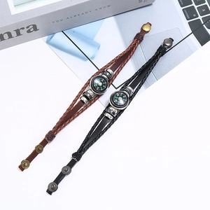 Detailopname van vintage leren gevlochten armbanden met kompas en bronzen drukknoop