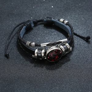 Macro detail of multi-layer leather bracelet featuring a galaxy pendant and metallic beads