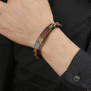 Braided leather bracelet with vintage metal magnetic clasp worn on male wrist