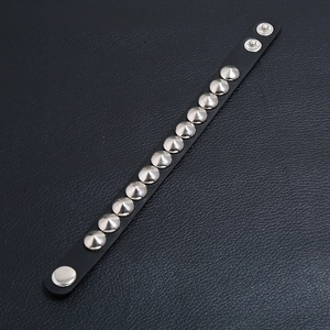 Punk black leather bracelet featuring silver cone studs and adjustable metal snaps