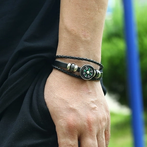 Close-up of multilayer leather bracelet featuring a black compass and vintage silver beads