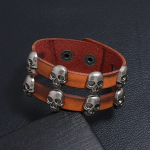Detail of vintage double-layer leather bracelet with silver skull rivets and snap closure