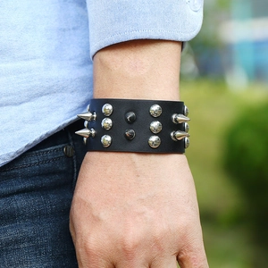 Punk leather bracelet with silver metal spikes and black rivets on a wide black wristband