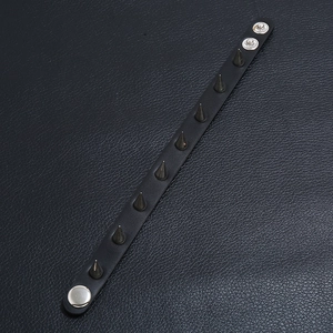 Punk black leather bracelet with silver metal spikes shown from a 45-degree angle