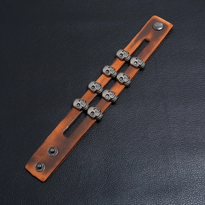 Vintage brown leather skull bracelet with double row metal studs and snap buttons