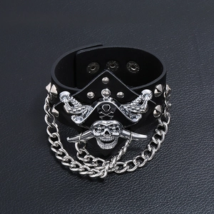 Punk rocker wide leather bracelet featuring metal chains, studs and pirate skull charm