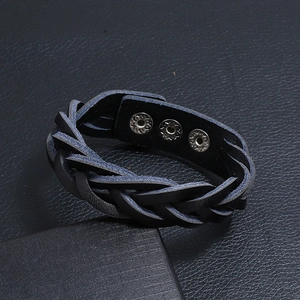 Dettaglio di un bracciale in pelle intrecciata nera da uomo con tre bottoni automatici regolabili