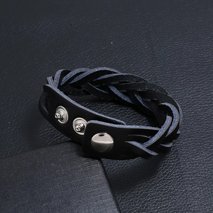 Dettaglio del bracciale in pelle intrecciata nera con tre bottoni automatici argento regolabili