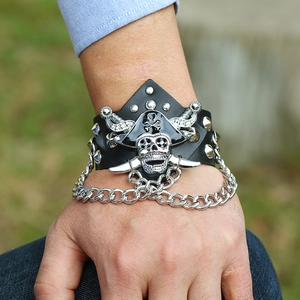 Punk leather bracelet featuring a silver pirate skull charm and hanging metal chains