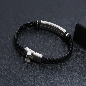 Détail d'un bracelet en cuir noir tressé avec fermoir en acier inoxydable brossé