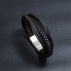 Detail of multi-layer black leather bracelet featuring a brushed silver magnetic clasp