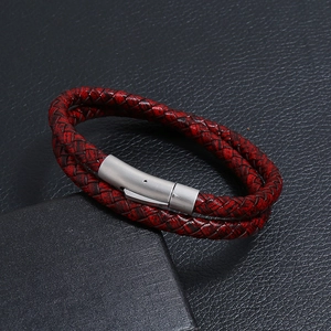 Macro detail of red and black braided leather bracelet with brushed metal magnetic clasp