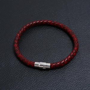 Detail of red and black braided leather bracelet with silver magnetic metal clasp