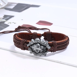 Macro shot of multilayer leather bracelet featuring a silver lion totem and woven details