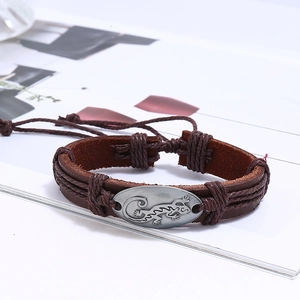 Detailed macro view of multilayer leather bracelet with lizard engraved metal charm