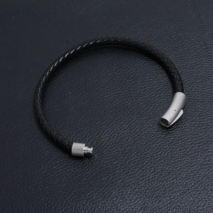 Dettaglio del bracciale in pelle nera intrecciata con chiusura magnetica in argento