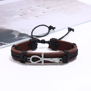 Detail of vintage brown leather bracelet with silver Ankh charm and adjustable rope
