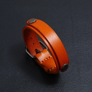 Vue détaillée du bracelet en cuir marron avec coutures orange et rivets argentés