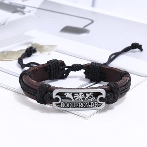 Détail d'un bracelet en cuir tressé à la main avec plaque en métal dauphin et tortue