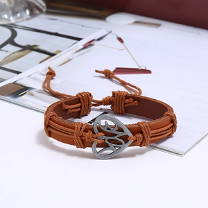 Close-up of vintage brown leather woven bracelet with silver-tone LOVE heart charm