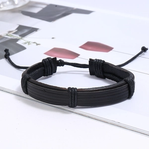Detail of multi-layer black braided leather bracelet with adjustable drawstring knot