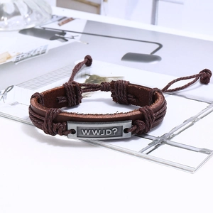 Détail d'un bracelet multicouche en cuir tressé avec une plaque en métal argenté WWJD