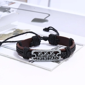 Vue macro du bracelet en cuir tressé avec plaque métallique Trinidad et tortues rétro