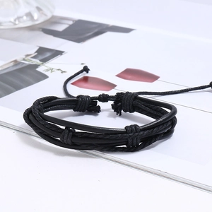 Detail view of multi-layered black leather braided bracelet set with rustic handmade cord knots