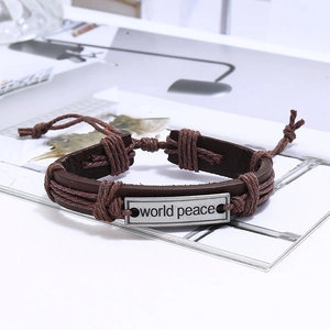 Vue macro d'un bracelet en cuir vintage avec plaque en métal gravée World Peace