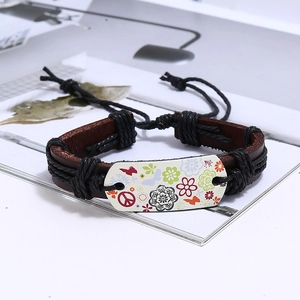 Macro view of vintage leather bracelet with woven rope and colorful peace sign charm