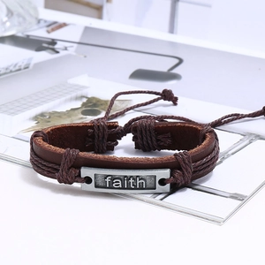 Vue détaillée d'un bracelet en cuir tressé marron avec plaque métallique Faith argentée