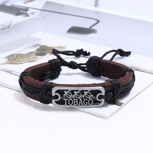 Détail du bracelet en cuir tressé avec breloque tortue et gravure Tobago vintage
