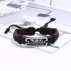 Détail du bracelet en cuir tissé main avec breloque en métal argenté sur le thème de Curacao