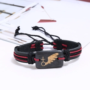 Détail du bracelet punk en cuir tressé avec pendentif aile et cordon rouge décoratif