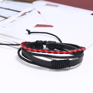 Détail d'un bracelet en cuir multicouche style punk avec cordons tressés rouges et noirs